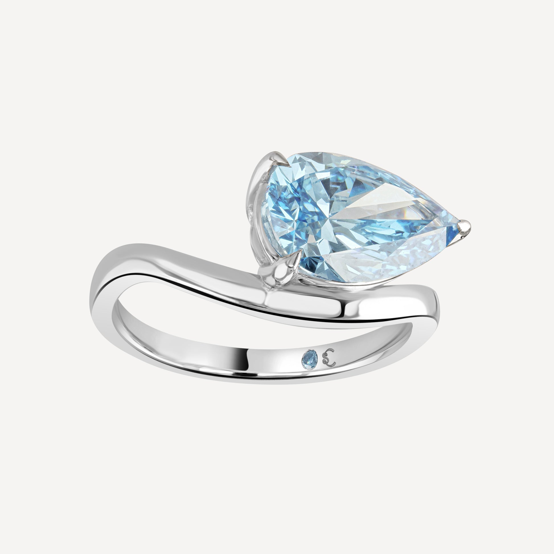 Side view close up of 3 carat blue pear-cut lab-grown diamond Drift Float Ring against white background