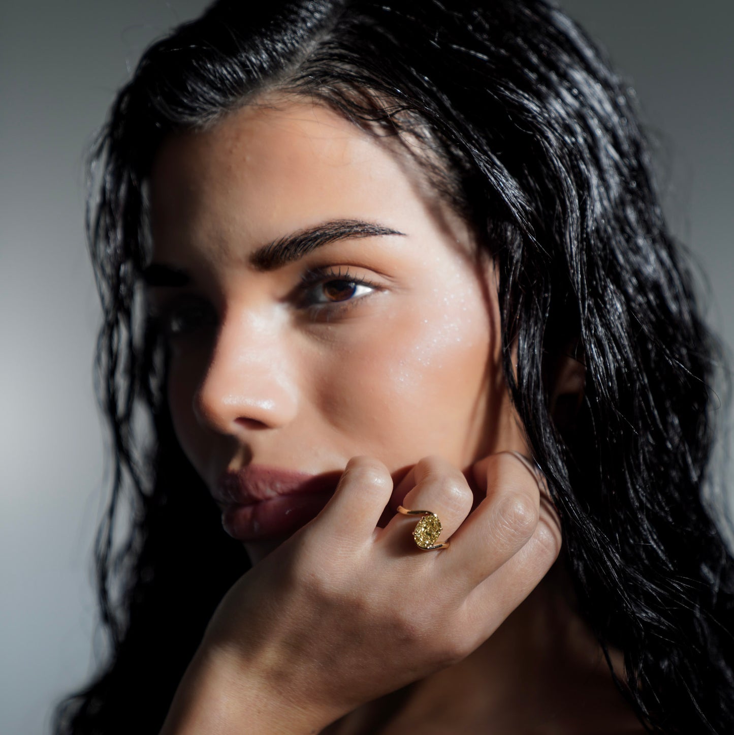 Side view of model wearing Glow Float Ring highlighting 3 carat oval-cut yellow lab-grown diamond