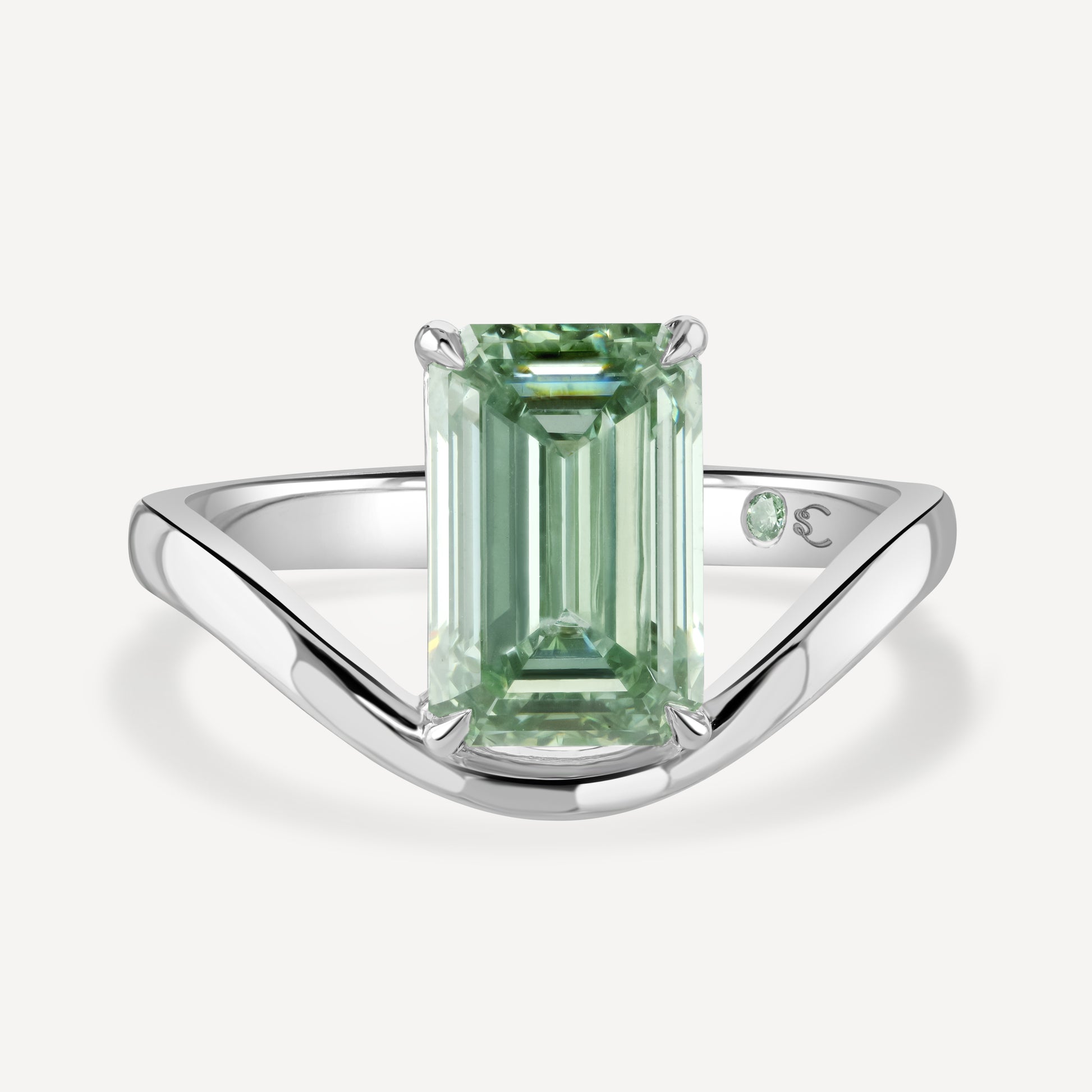 Close up of 3 carat green emerald-cut lab-grown diamond Poise Float Ring against white background